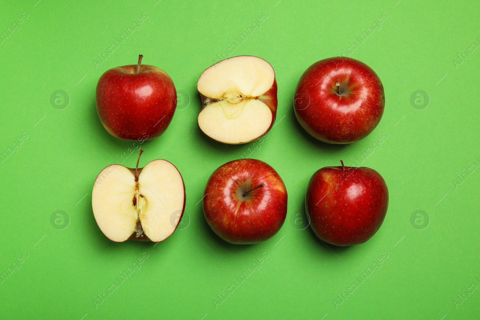 Photo of Flat lay composition with ripe juicy red apples on green background