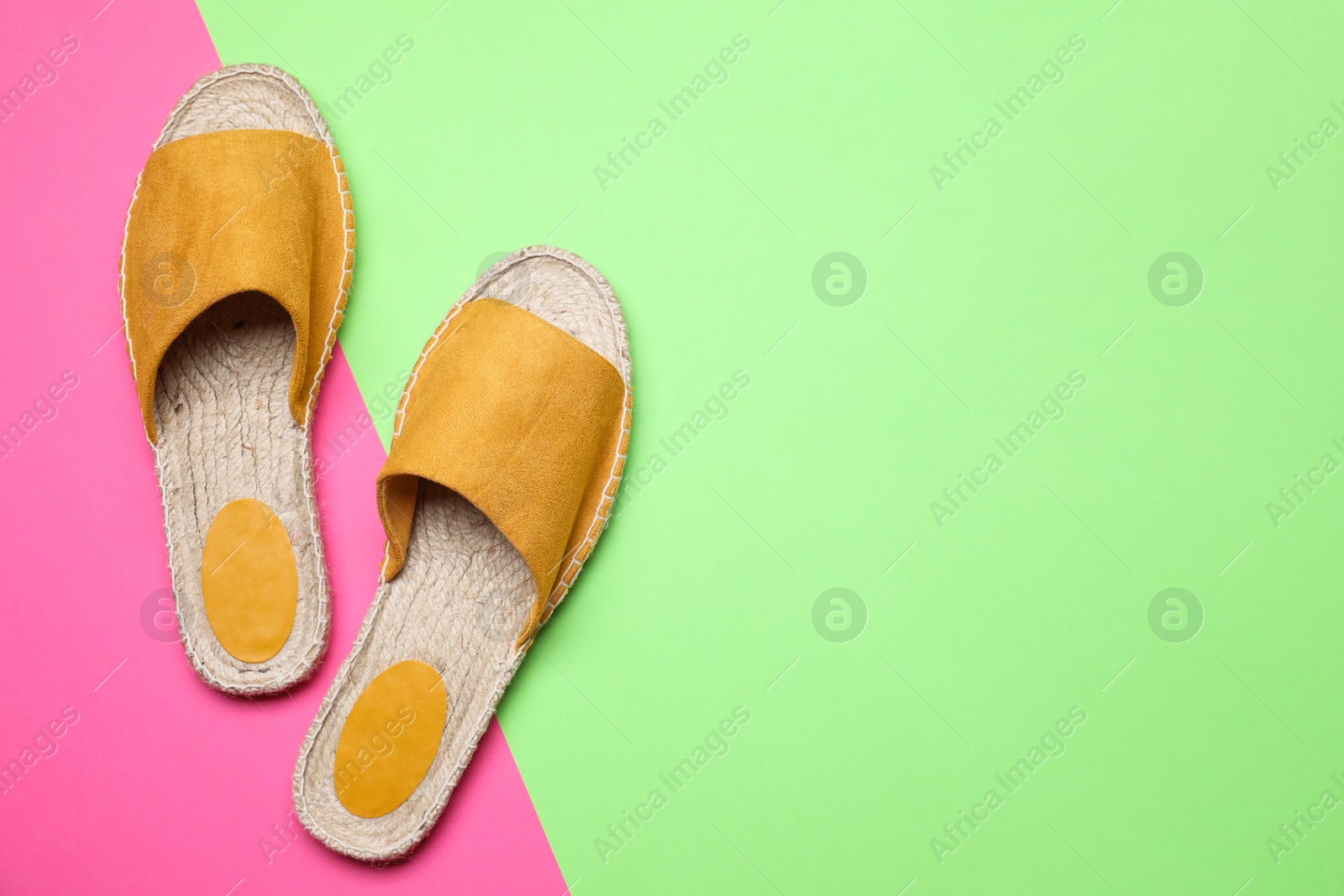 Photo of Pair of stylish female shoes on color background, top view with space for text. Beach objects