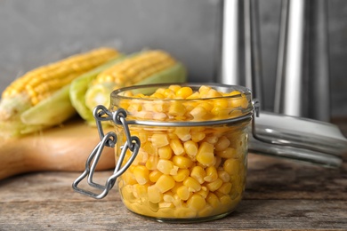 Photo of Jar with corn kernels on wooden table