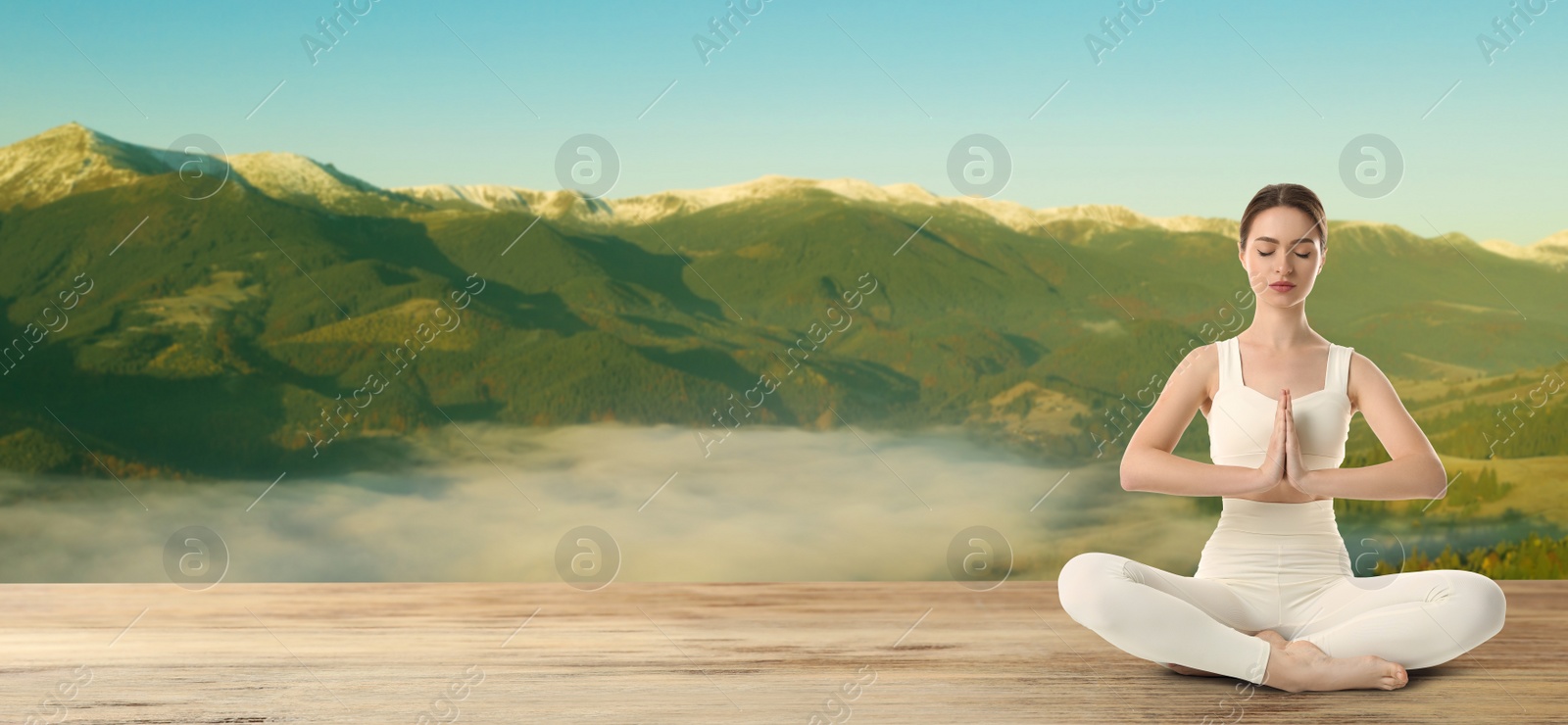 Image of Young woman practicing yoga on wooden surface against beautiful mountain landscape, space for text. Banner design