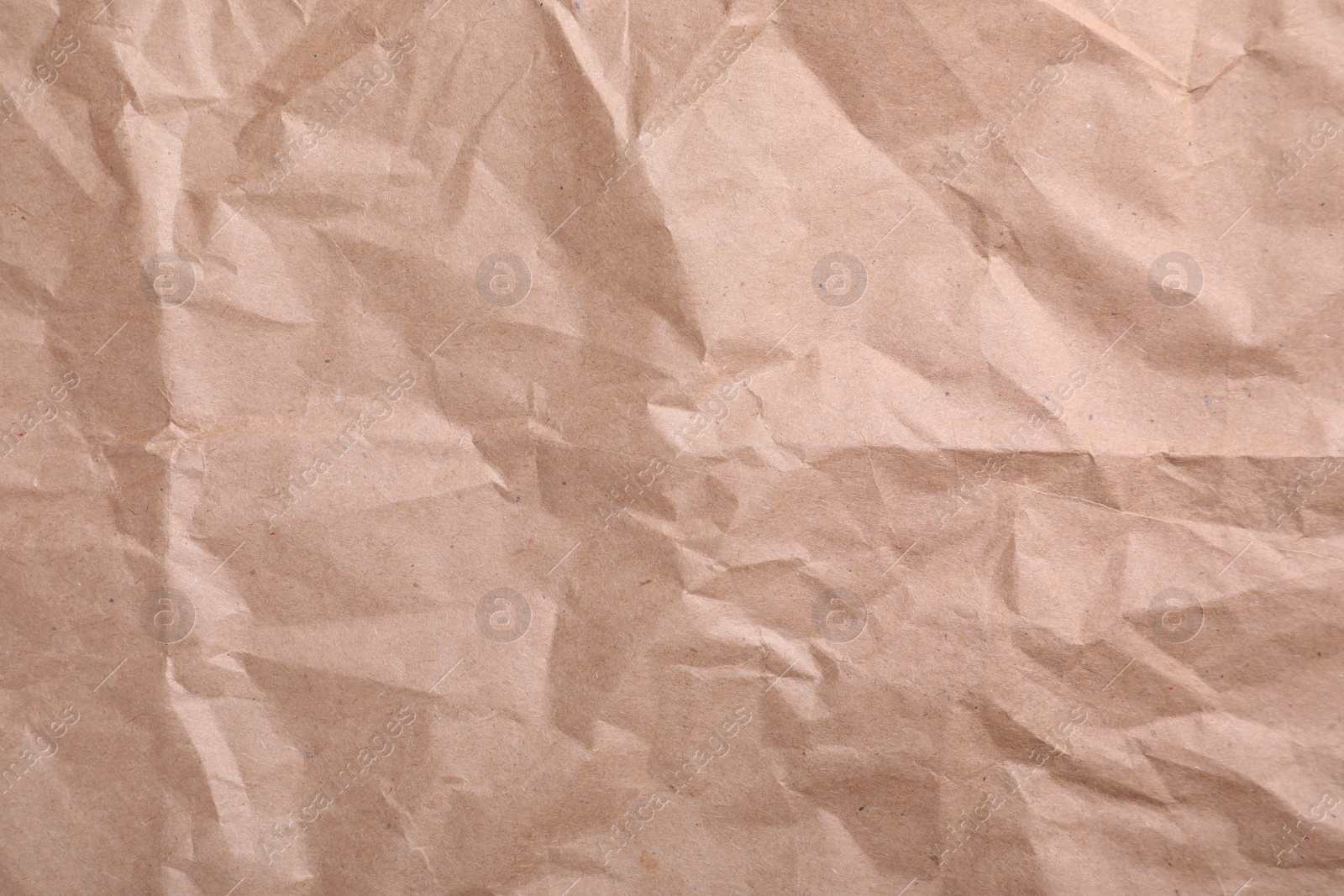 Photo of Texture of wrinkled kraft paper bag as background, closeup