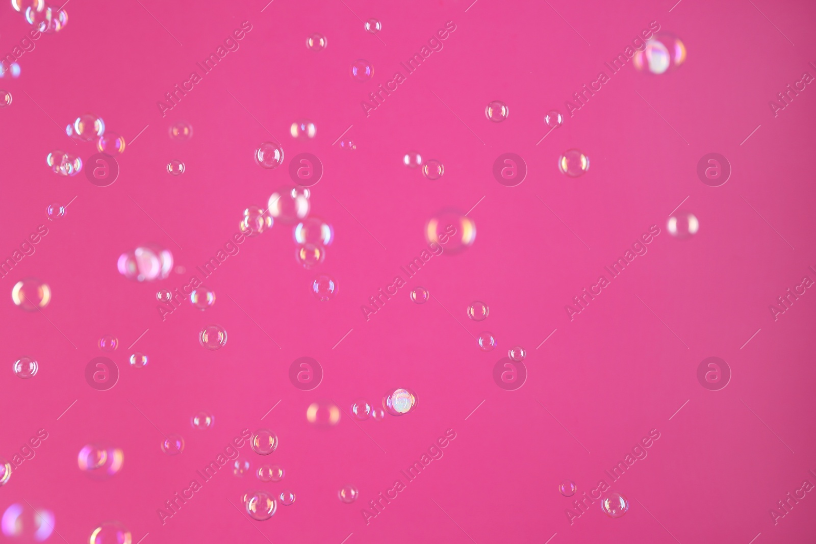 Photo of Beautiful transparent soap bubbles on pink background
