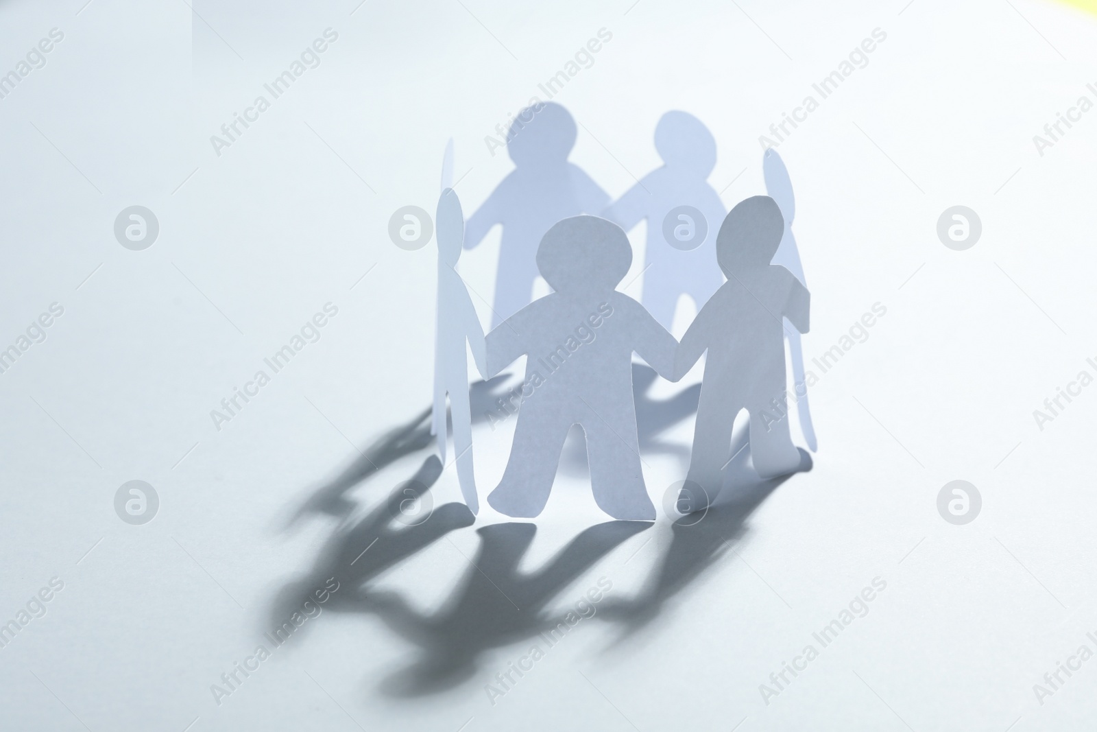 Photo of Paper people chain making circle on white background. Unity concept