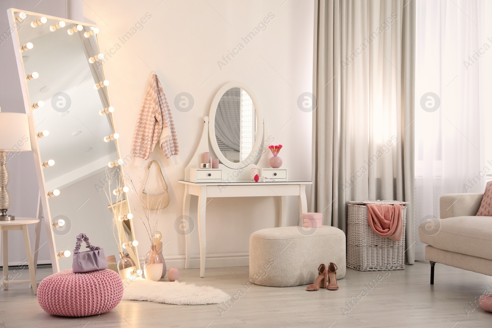 Photo of Large mirror with light bulbs and dressing table in stylish room. Interior design