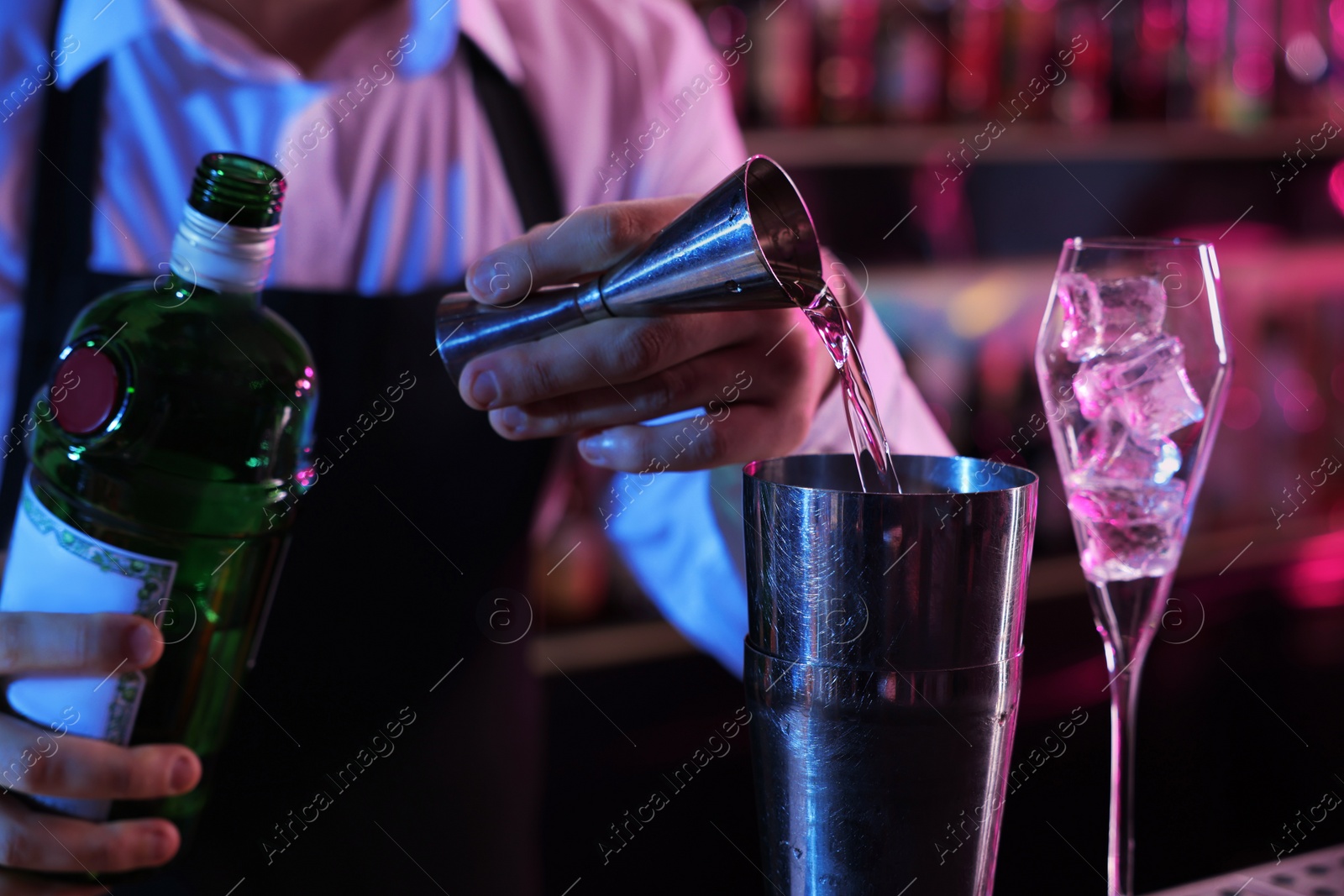 Photo of Bartender making fresh alcoholic cocktail in bar, closeup