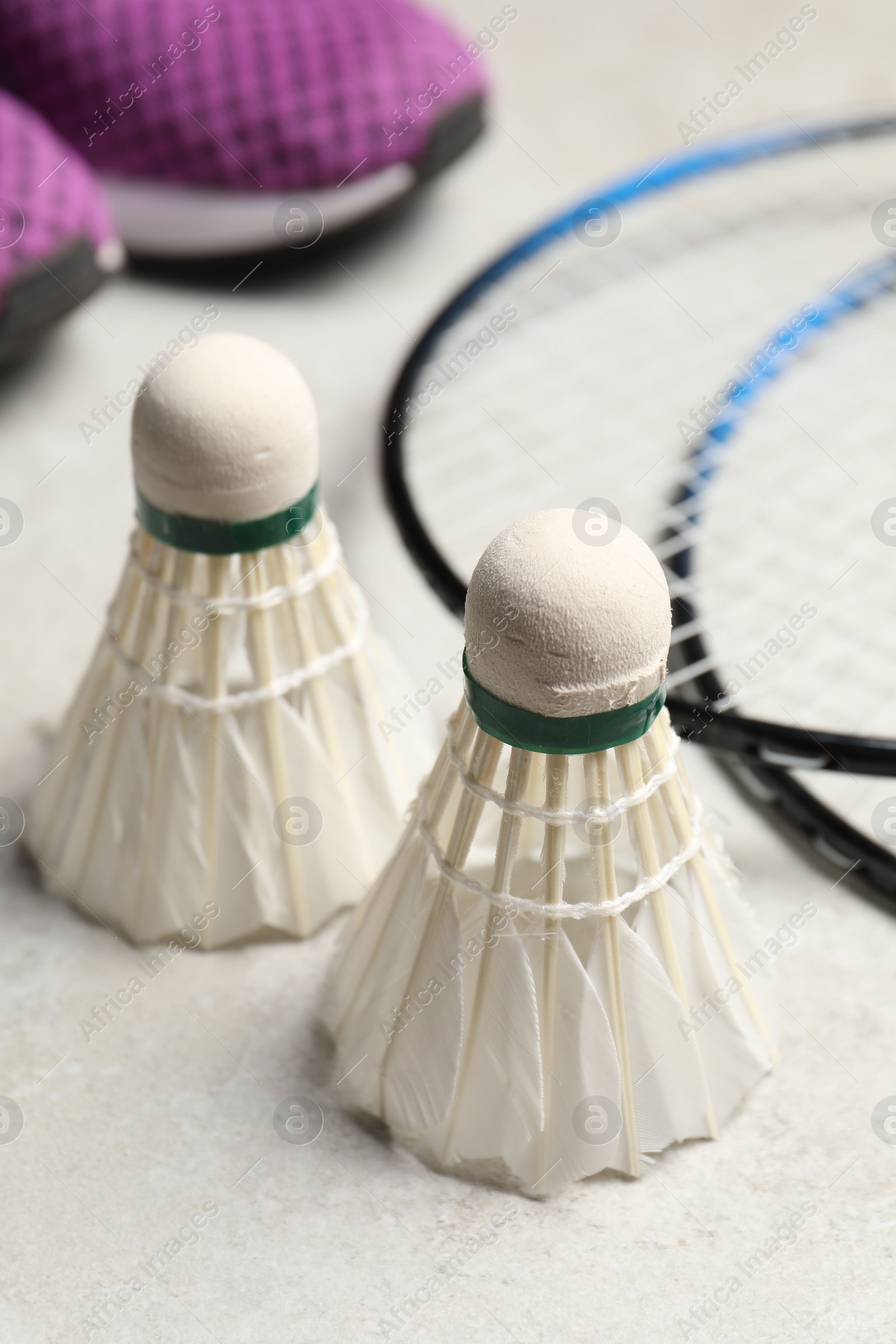 Photo of Feather badminton shuttlecocks and rackets on gray background, closeup