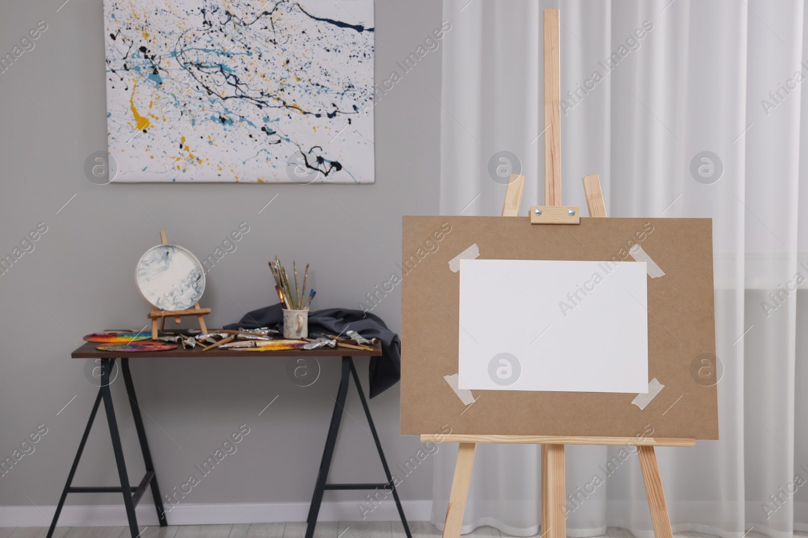 Photo of Wooden easel with taped paper in artist's studio