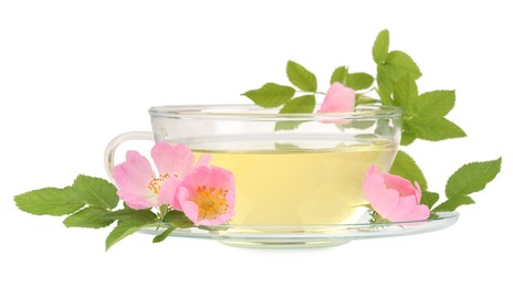 Photo of Aromatic herbal tea in glass cup, flowers and green leaves isolated on white