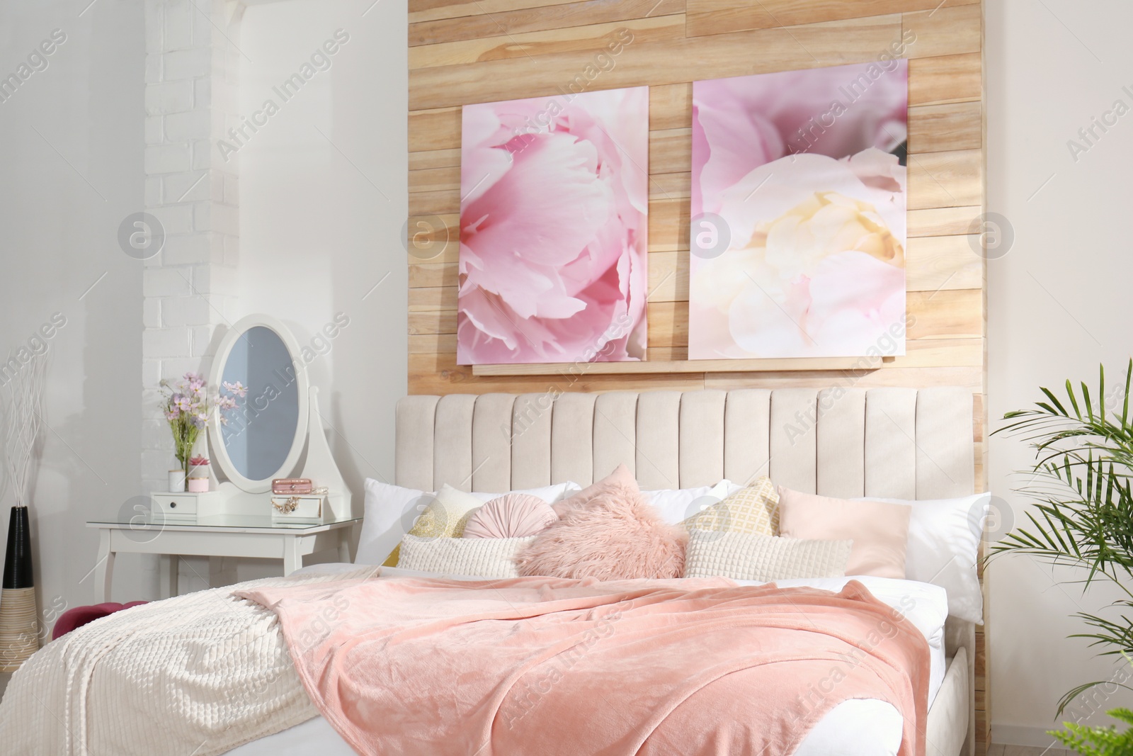 Photo of Stylish room interior with large comfortable bed and beautiful paintings