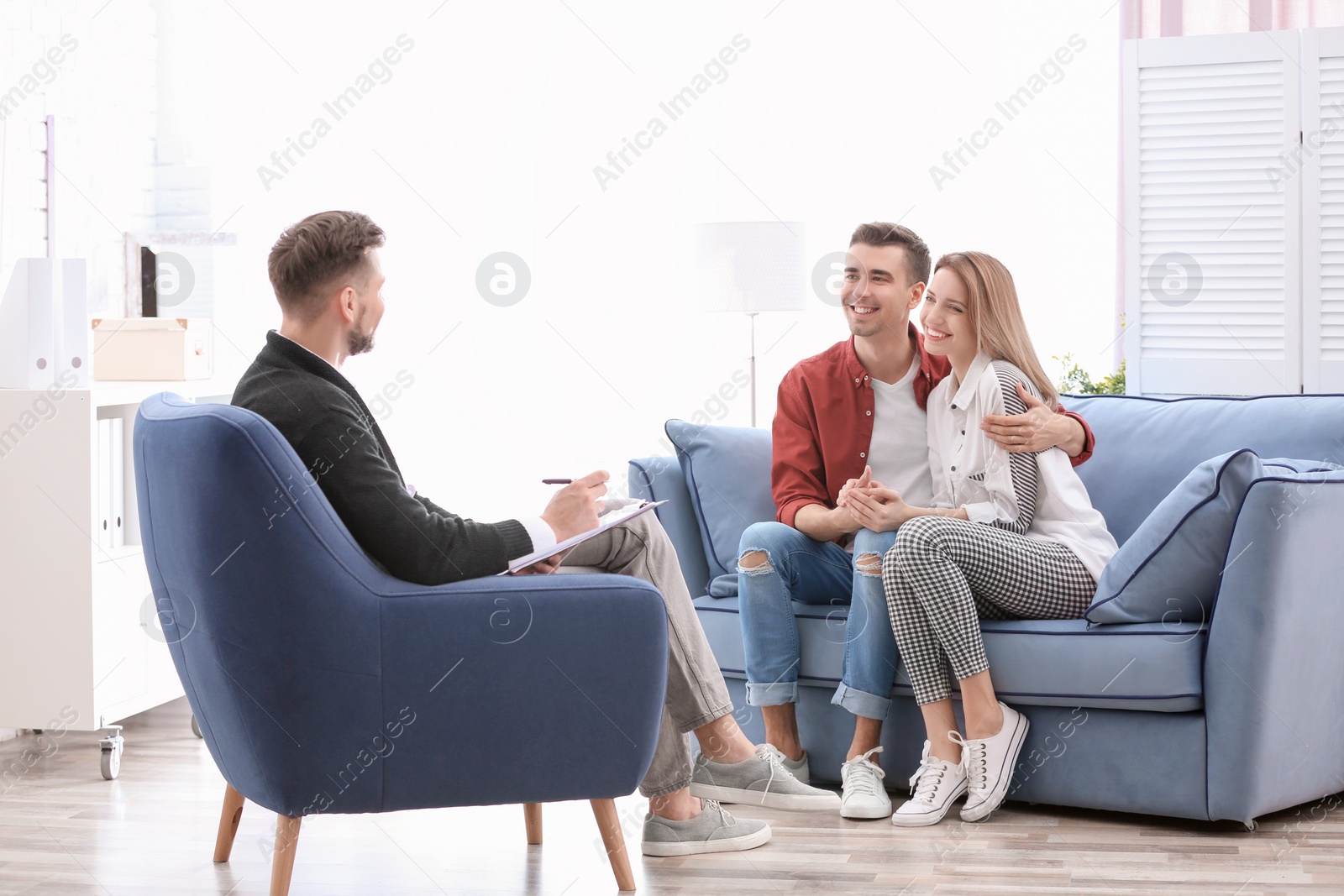 Photo of Young happy couple after therapy session with family psychologist indoors