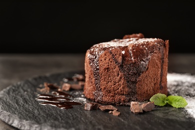 Slate plate of delicious fresh fondant with hot chocolate on table. Lava cake recipe