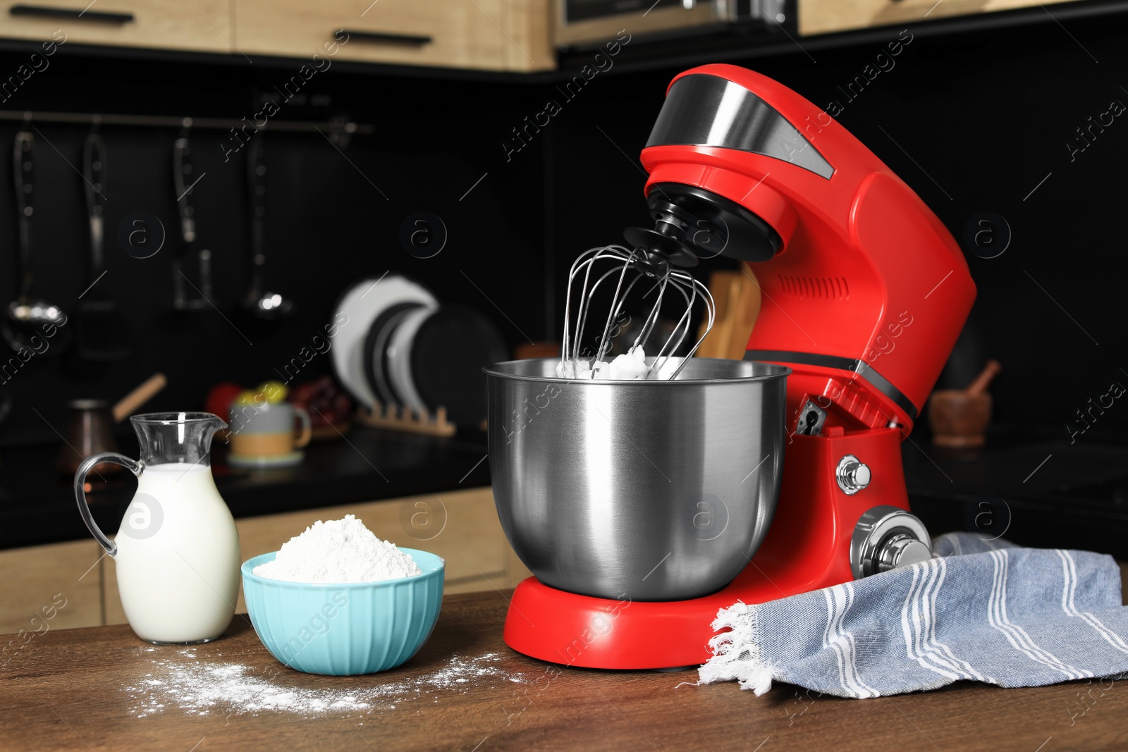 Photo of Modern red stand mixer and ingredients on wooden table in kitchen