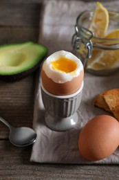 Photo of Soft boiled egg served for breakfast on wooden table