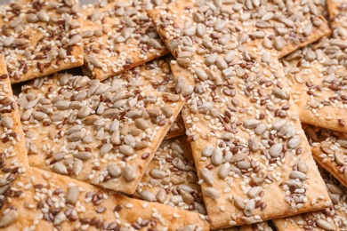 Photo of Many delicious crackers as background, closeup view