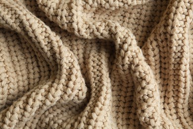 Beautiful beige knitted fabric as background, top view