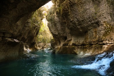 Photo of Picturesque view of clean river near cliffs and waterfall outdoors