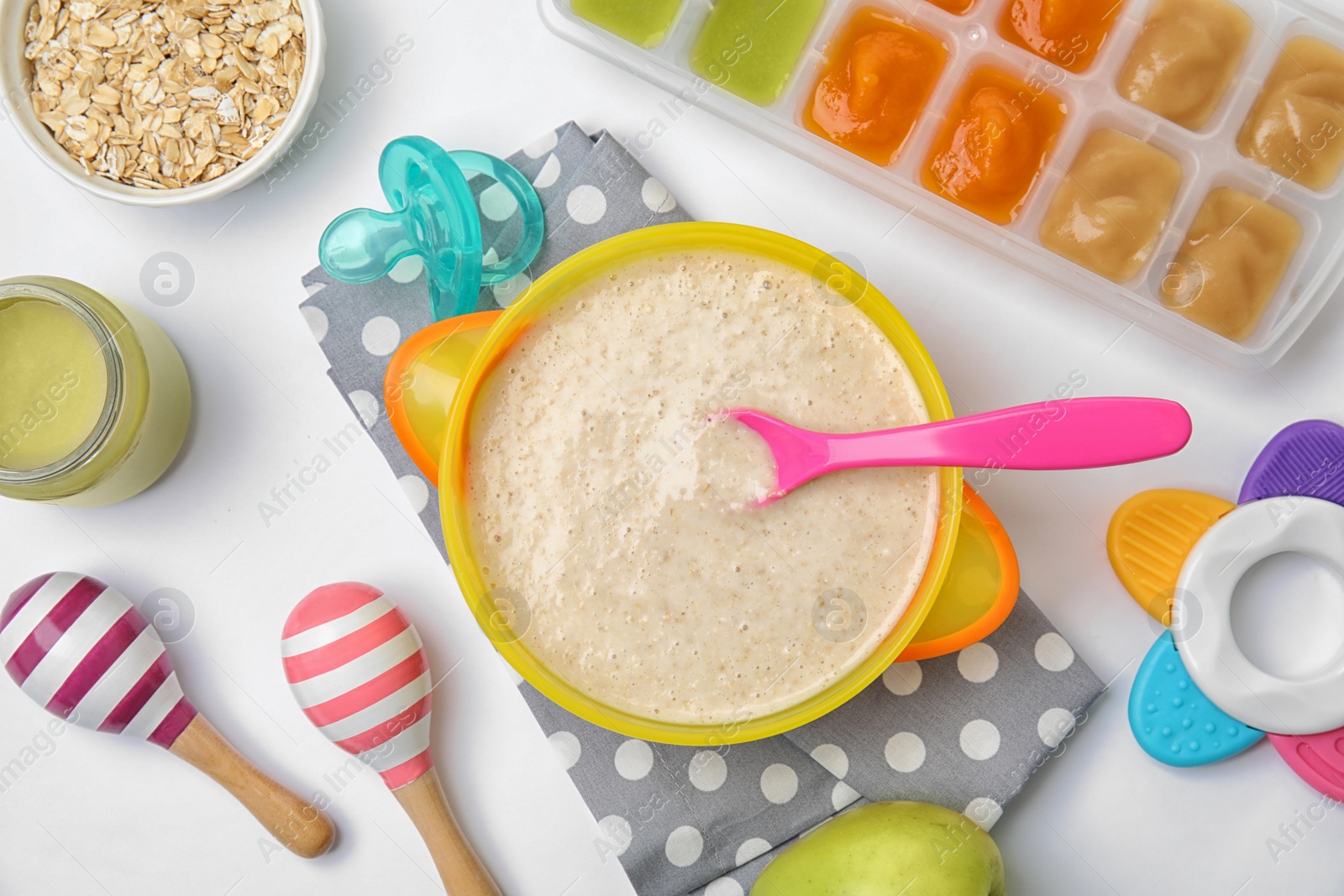 Photo of Flat lay composition with bowl of healthy baby food on white background