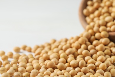 Photo of Heap of soy on white table, closeup. Space for text