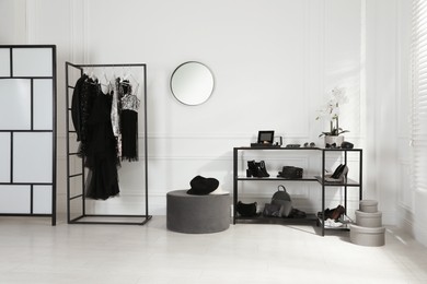 Photo of Stylish dressing room interior with trendy clothes, shoes and accessories