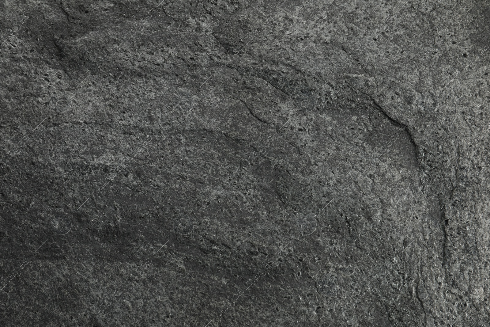 Photo of Texture of dark grey stone surface as background, closeup