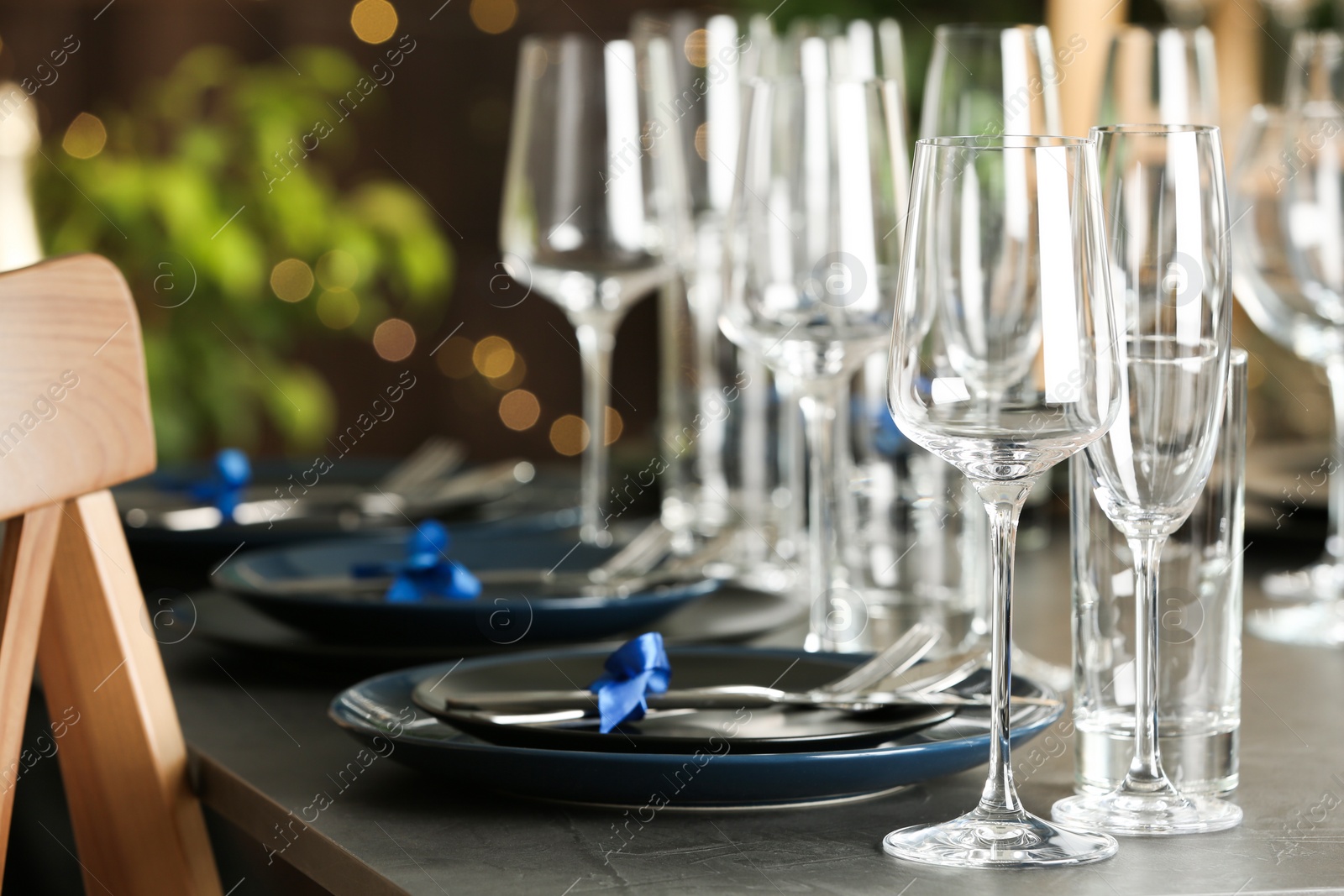 Photo of Table setting with empty glasses, plates and cutlery indoors