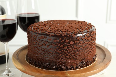 Photo of Delicious chocolate truffle cake and red wine on table