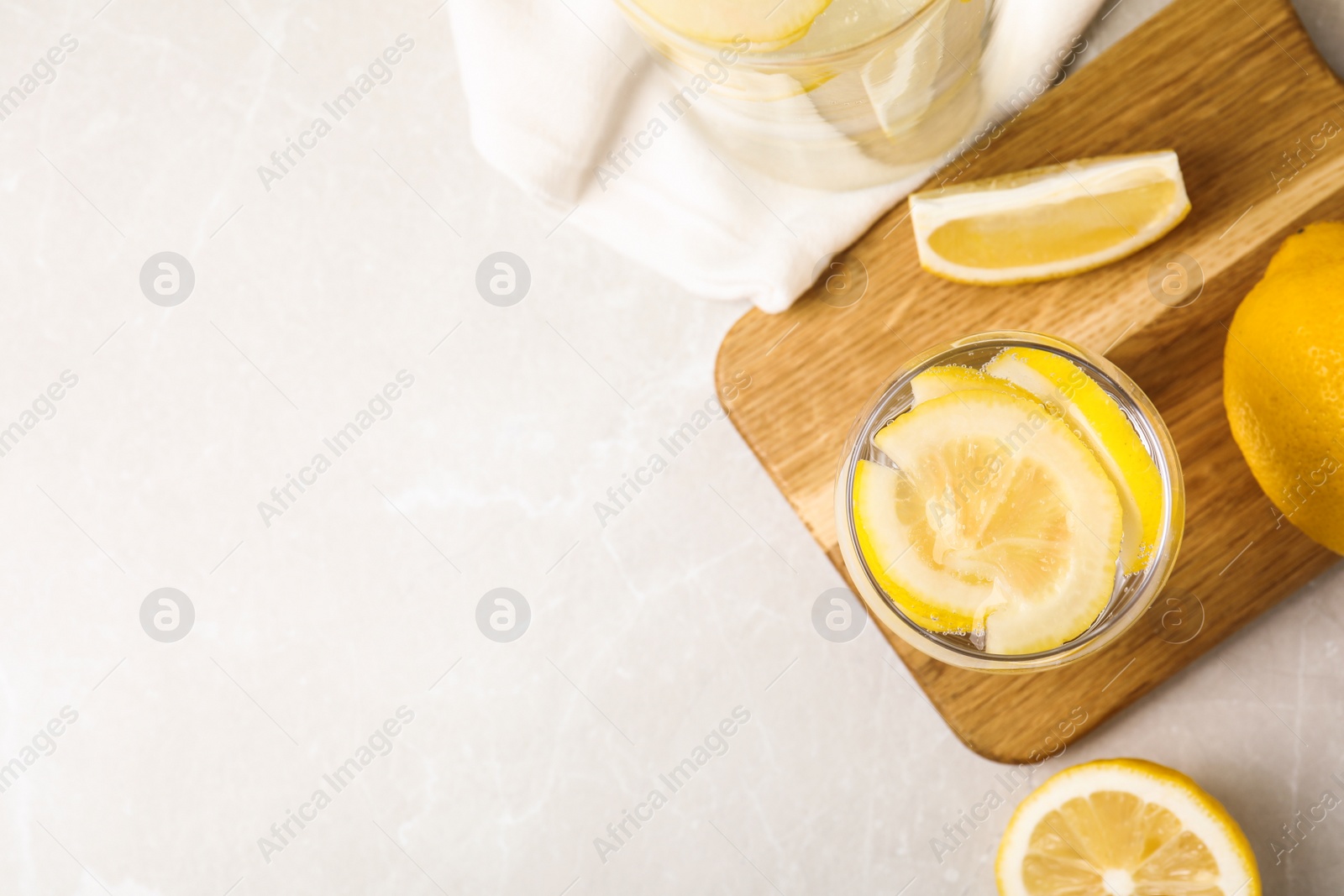 Photo of Soda water with lemon slices on light table, flat lay. Space for text
