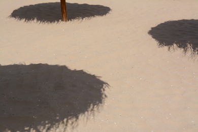 Photo of Shadows from umbrellas on sandy beach. Tropical resort