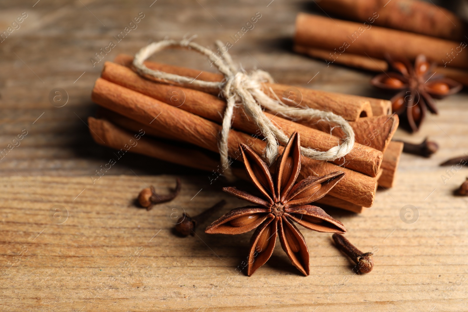 Photo of Different aromatic spices on wooden table, closeup