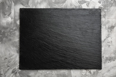 Black textured slate board on marble background