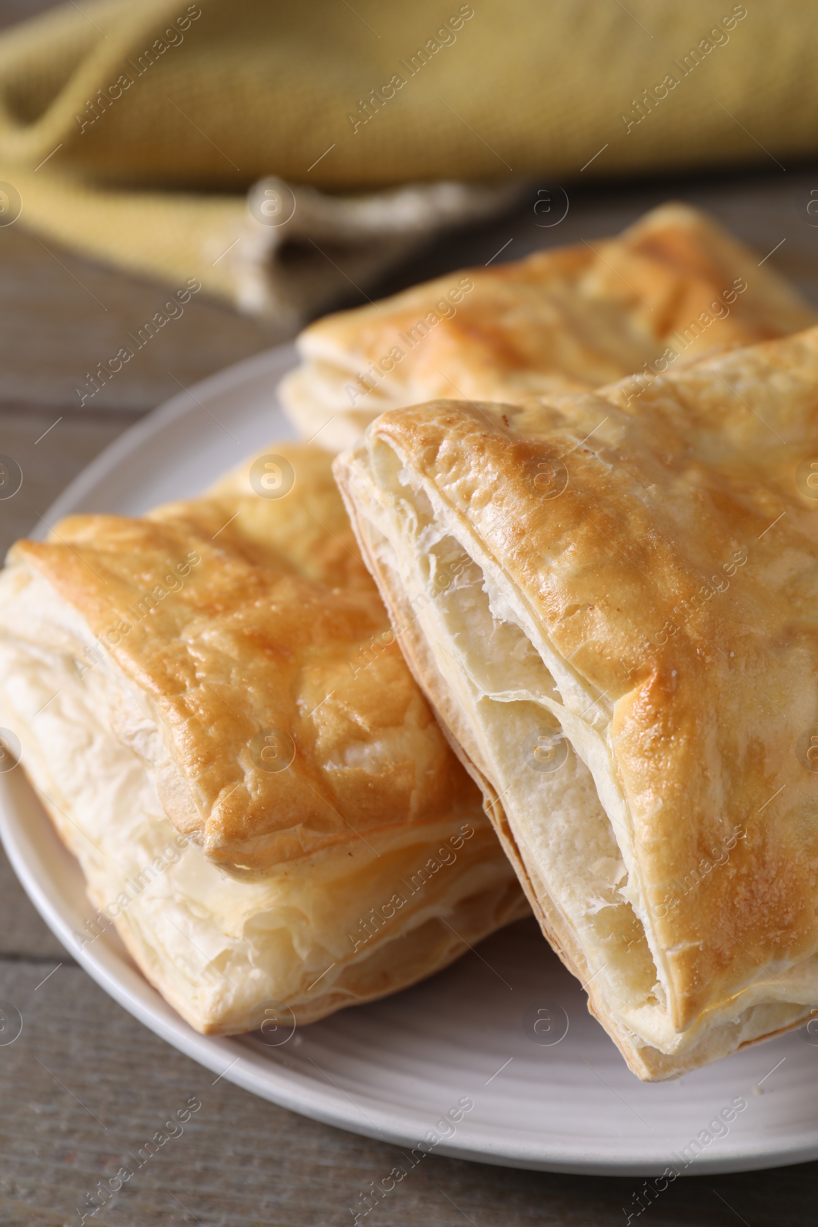 Photo of Delicious fresh puff pastries on wooden table, closeup