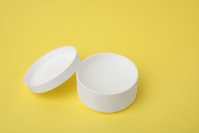 Photo of Jar of petroleum jelly on yellow background