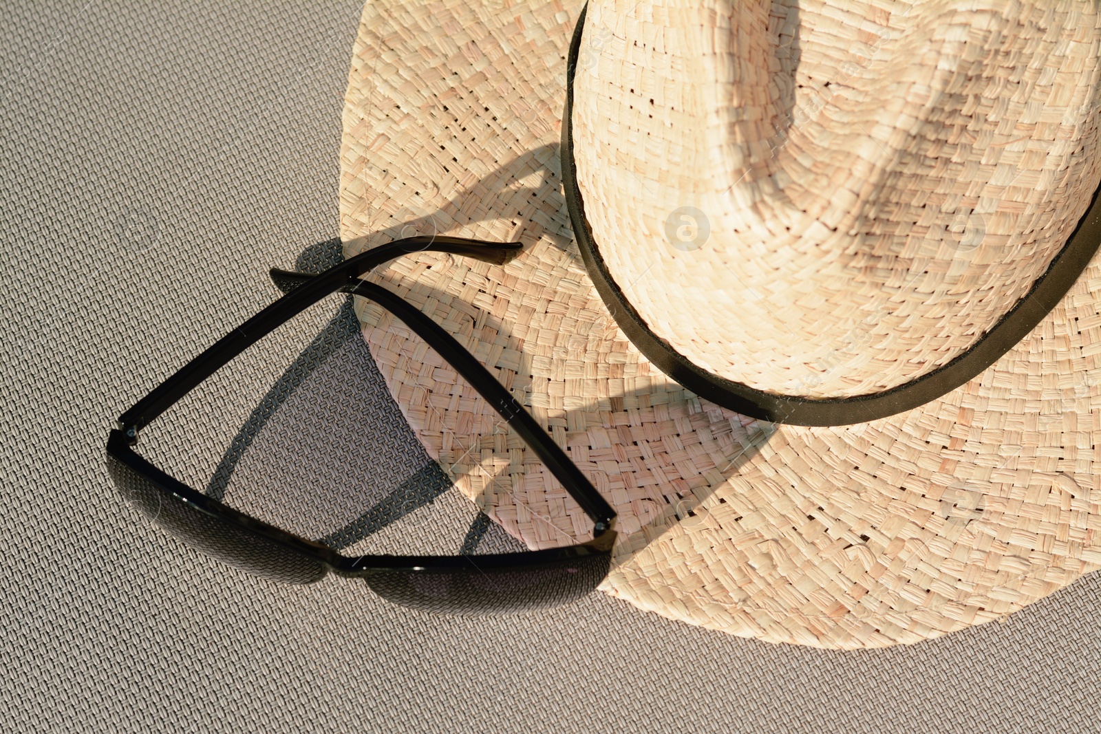 Photo of Stylish hat and sunglasses on grey surface, flat lay