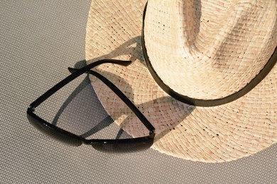 Photo of Stylish hat and sunglasses on grey surface, flat lay