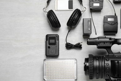 Photo of Flat lay composition with camera and video production equipment on light grey background. Space for text