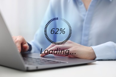 Loading progress. Woman working on laptop at table indoors, closeup