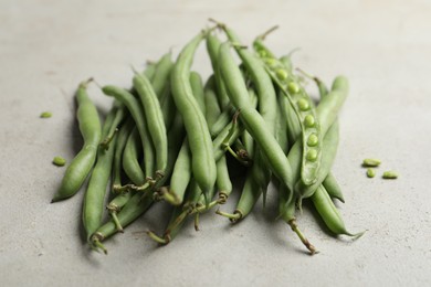 Photo of Fresh green beans on light grey table, closeup