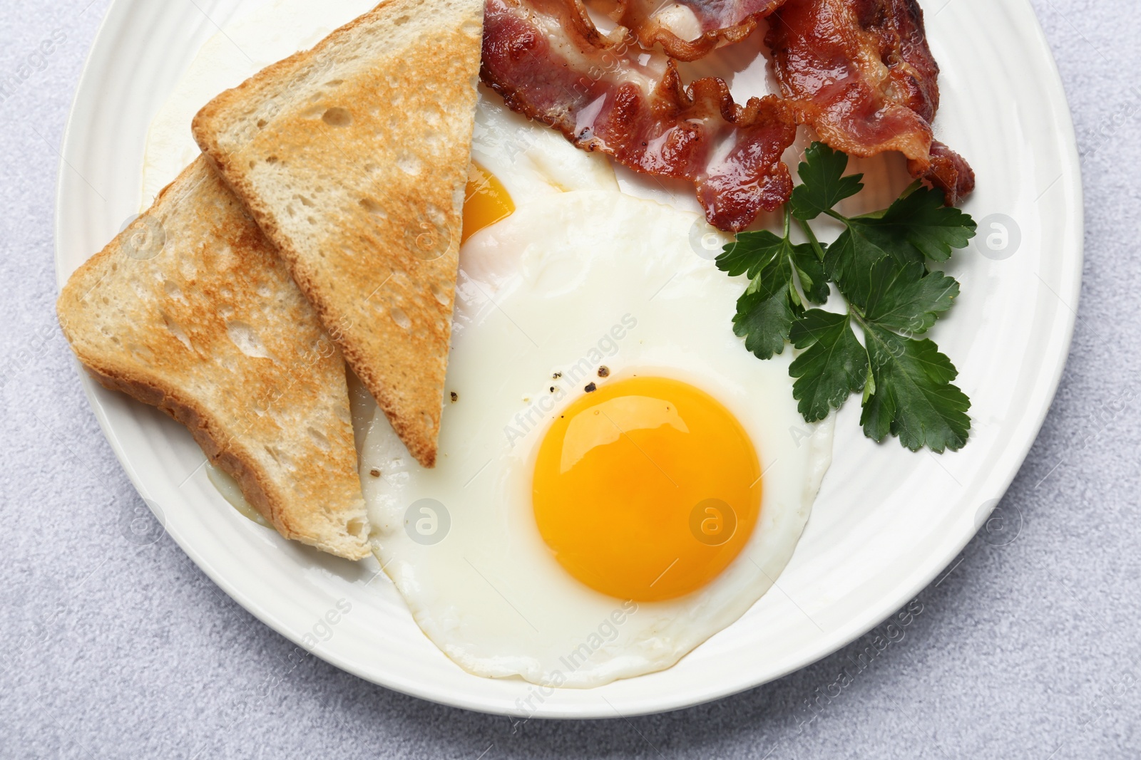 Photo of Delicious breakfast with sunny side up egg on light table, top view