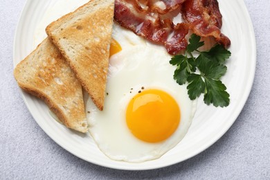 Delicious breakfast with sunny side up egg on light table, top view