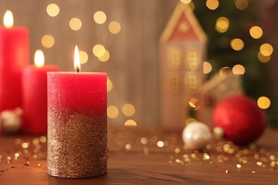 Photo of Beautiful burning candles with Christmas decor on wooden table against blurred festive lights, space for text