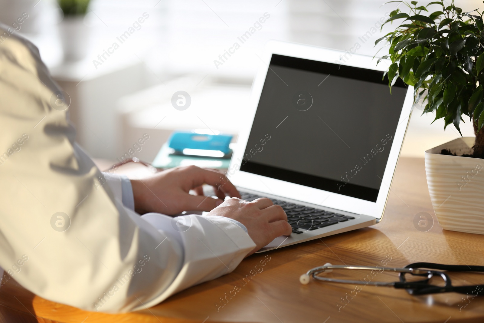 Photo of Professional doctor working on laptop in office, closeup