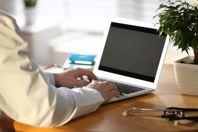 Professional doctor working on laptop in office, closeup