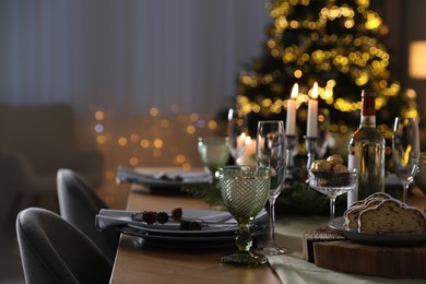 Photo of Christmas table setting with festive decor and dishware indoors