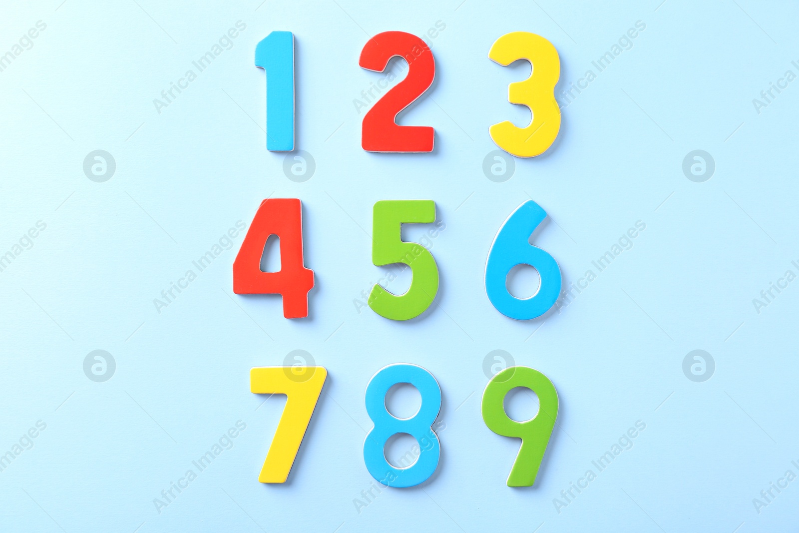 Photo of Colorful numbers on light blue background, flat lay