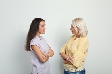 Portrait of young woman and her mother-in-law on white background. Happy family