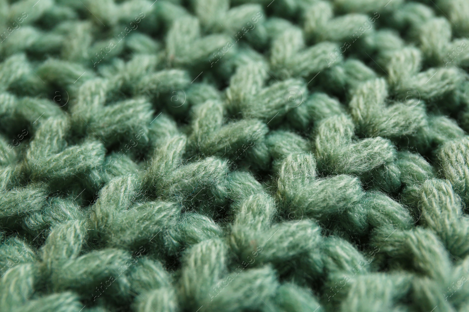 Photo of Beautiful pale green knitted fabric as background, closeup