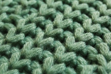 Beautiful pale green knitted fabric as background, closeup