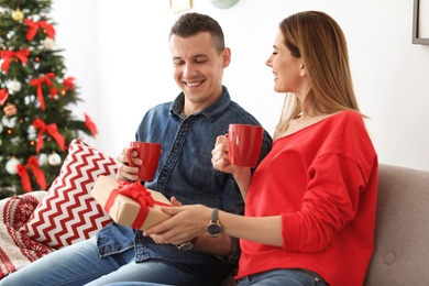 Young couple with Christmas gift at home