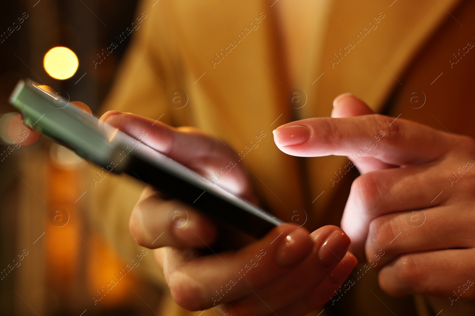 Photo of Woman using smartphone on blurred background, closeup