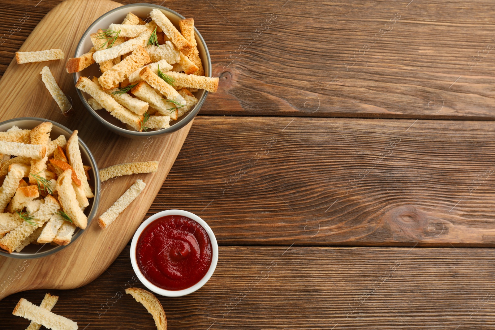 Photo of Delicious hard chucks with ketchup on wooden table, flat lay. Space for text